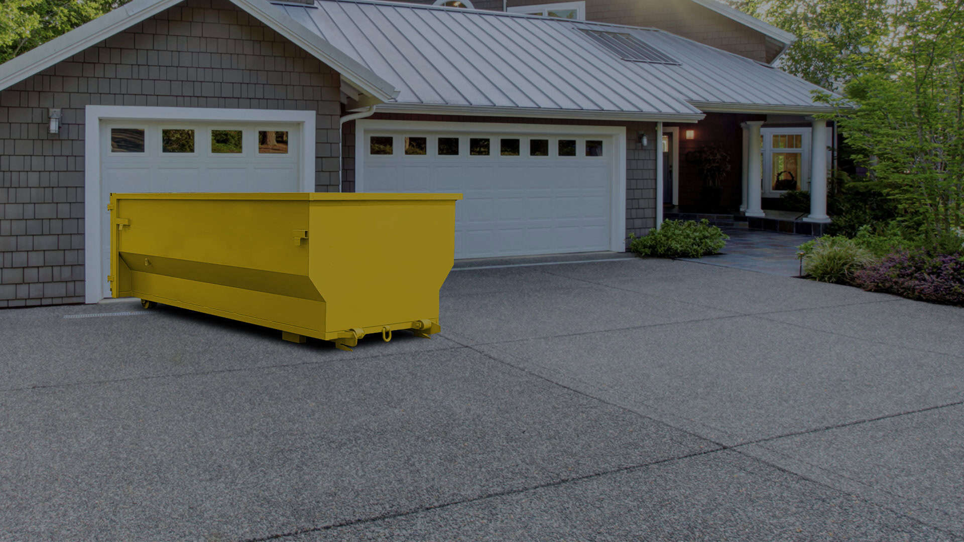 Commercial yellow waste container in residential driveway for waste management.